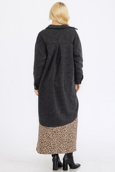 Person wearing a long dark gray coat with a leopard print hem on a white background