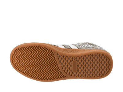 Close-up of a shoe sole with brown rubber and white and gold patterned material on a white background