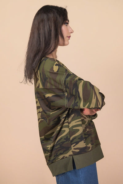 Woman wearing a camouflage jacket on a beige background