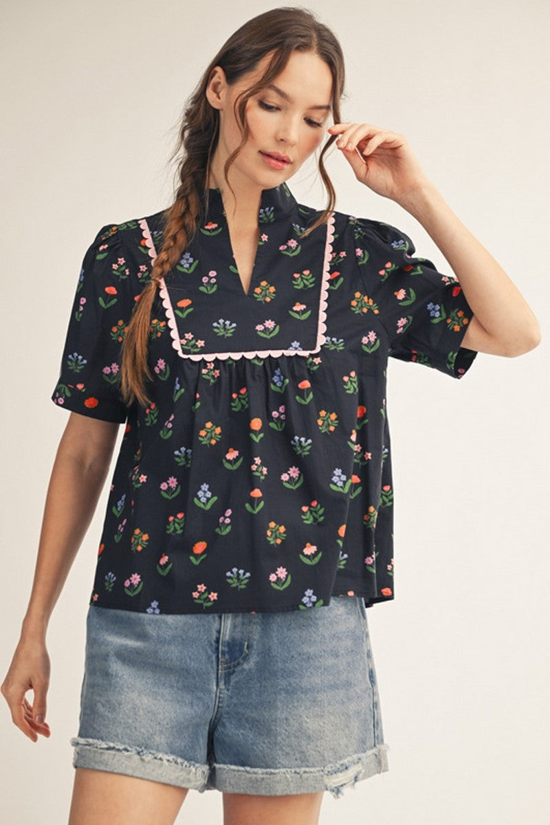 model wearing black floral top & cuffed denim shorts