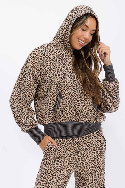 Woman wearing a leopard print hoodie and pants set on a white background