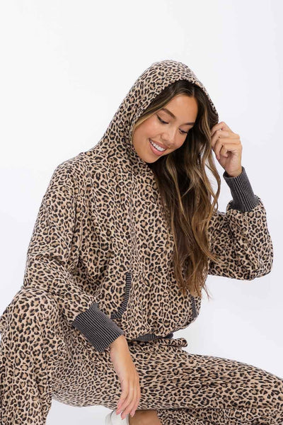 Woman wearing a leopard print hoodie and pants on a white background