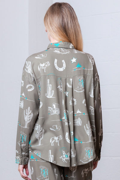 Person wearing a patterned shirt with western-themed designs against a white background