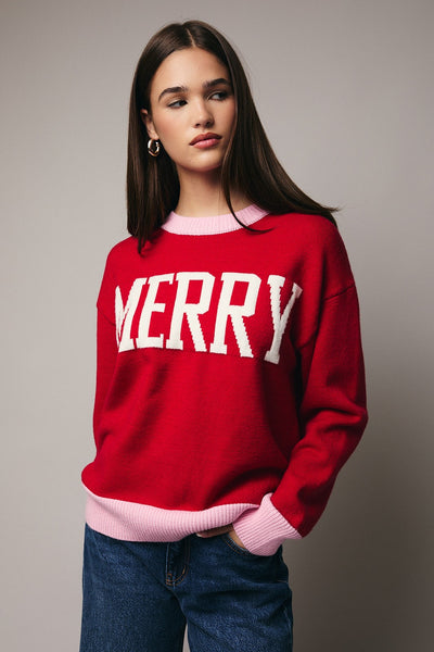 Person wearing a red sweater with 'MERRY' text on a plain background