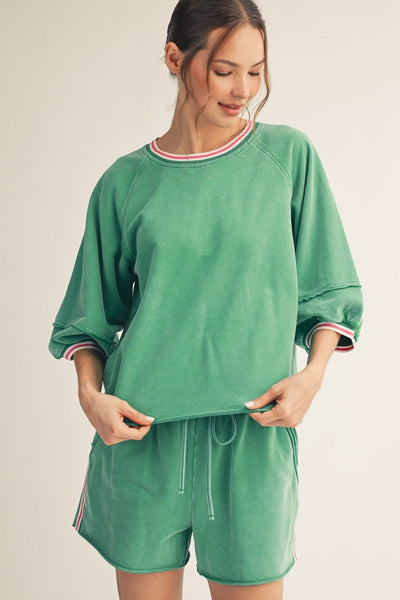 model wearing a green top & shorts
