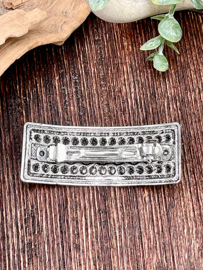 Silver hair clip on a wooden surface
