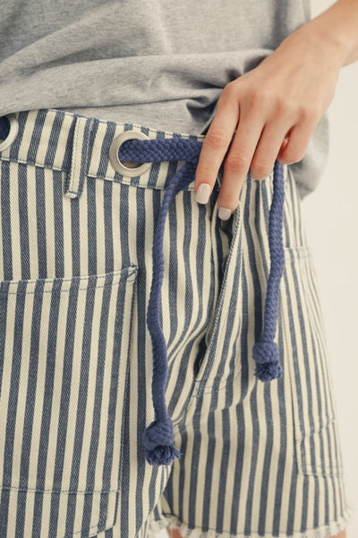 close up of braided tie on blue striped shorts