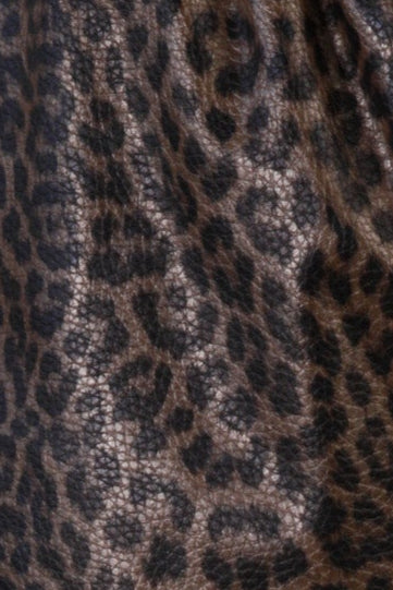 Leopard print shorts worn by a person on a beige background