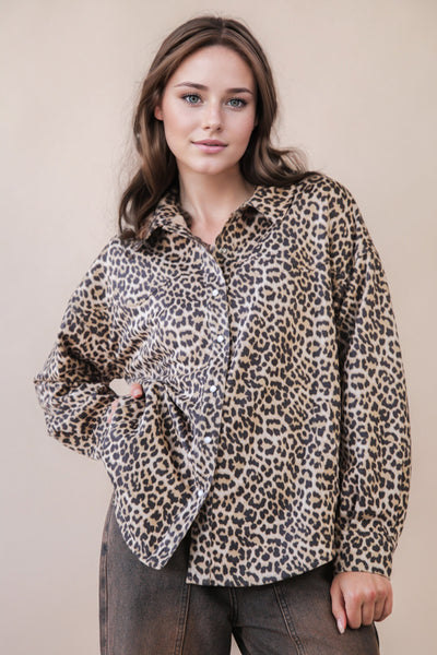 Woman wearing a leopard print shirt against a beige background