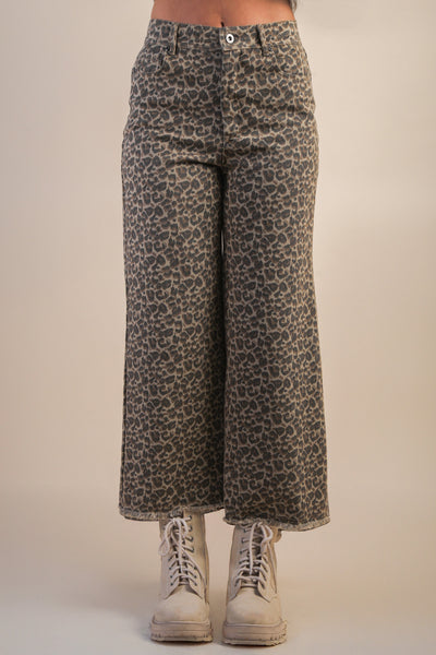 Leopard print pants worn by a person on a beige background