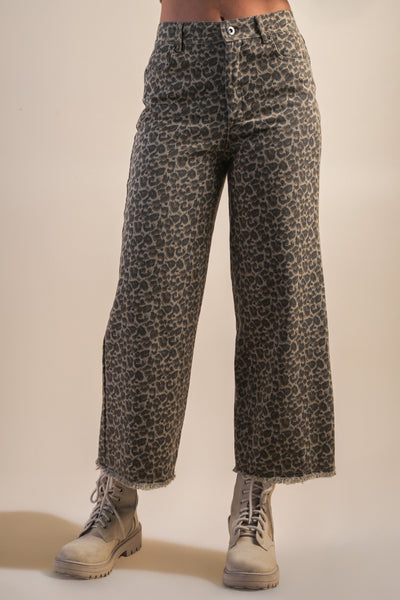 Leopard print pants worn by a person on a beige background