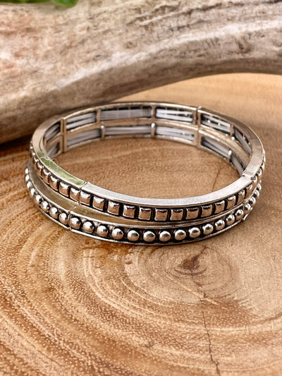 stack of two silver bracelets on wooden background