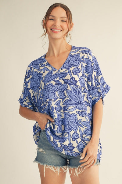 model wearing a blue & white floral top with cutoff denim shorts