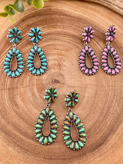 pink, blue & green teardrop earrings on wooden background