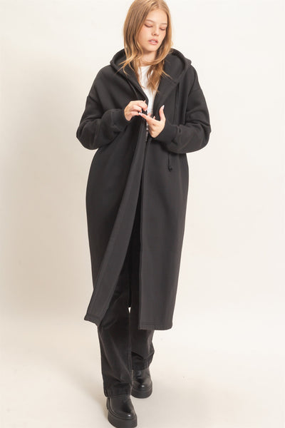 model wearing a long black coat with a hood