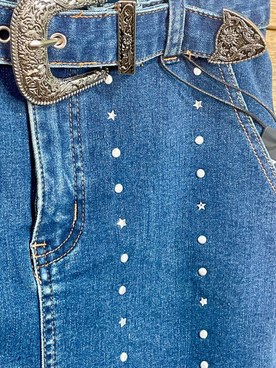 Close-up of blue jeans with decorative studs and a belt with a silver buckle.