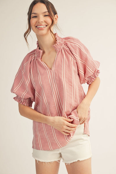 model wearing a red striped top & white shorts