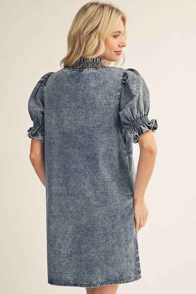 model wearing denim dress with tan background