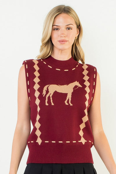 Woman wearing a maroon sleeveless top with horse design and black skirt on a white background