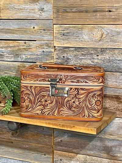 Tooled leather box on a wooden shelf with a rustic wooden wall background