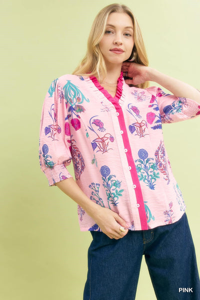 Woman wearing a pink floral blouse with a green background