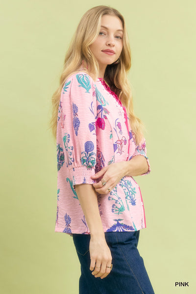 Woman wearing a pink floral blouse against a light green background