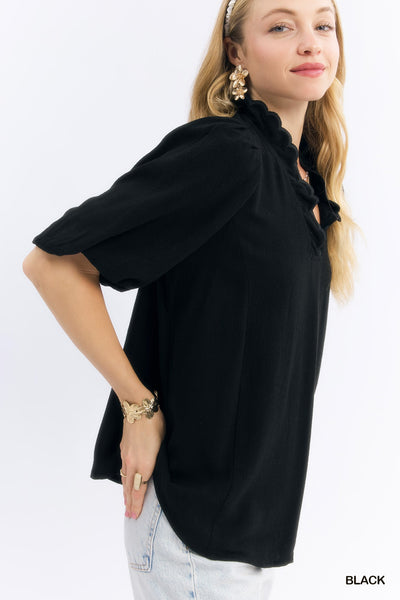 model wearing black scalloped v neck top