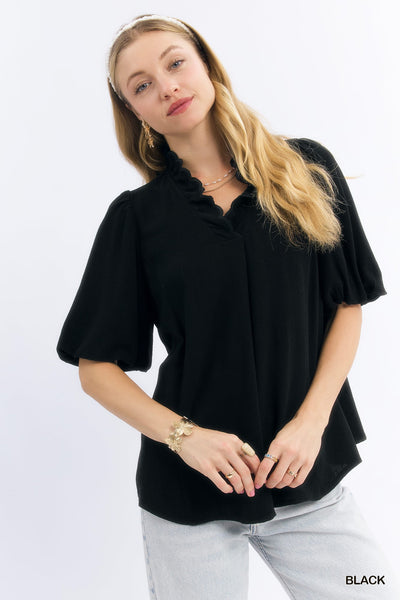 model wearing black scalloped v neck top