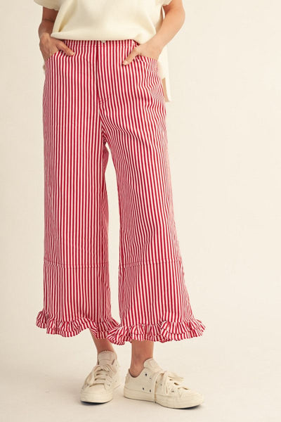 Person wearing red and white striped pants with a plain background