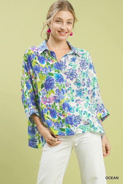 Woman wearing a colorful floral blouse against a light green background
