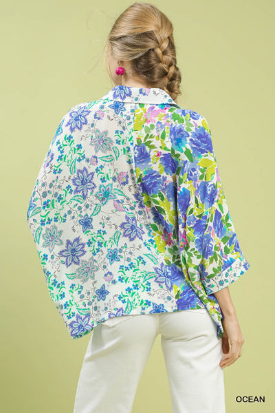 Woman wearing a colorful floral blouse with a green background