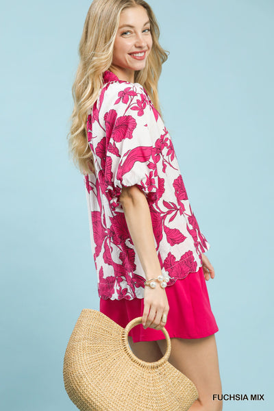 Woman wearing a pink and white floral kimono with a straw bag against a light blue background