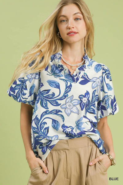 Woman wearing a blue floral blouse against a green background