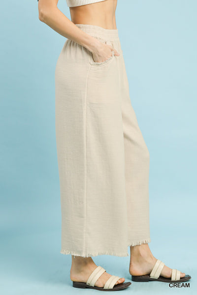 Beige wide-leg pants worn by a person on a light blue background
