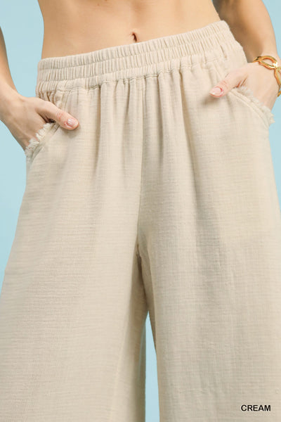Beige wide-leg pants worn by a person on a light blue background