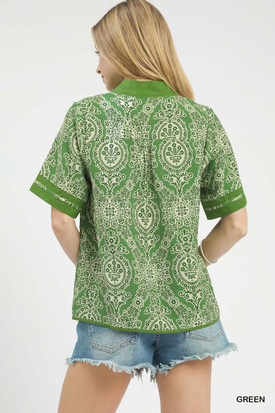 Woman wearing a green floral patterned shirt on a white background