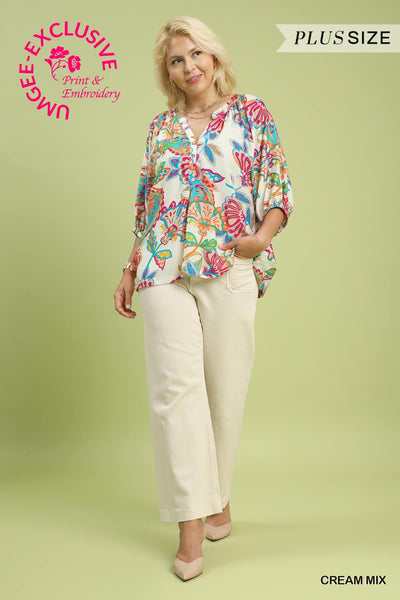 Woman wearing a colorful blouse and beige pants on a light green background