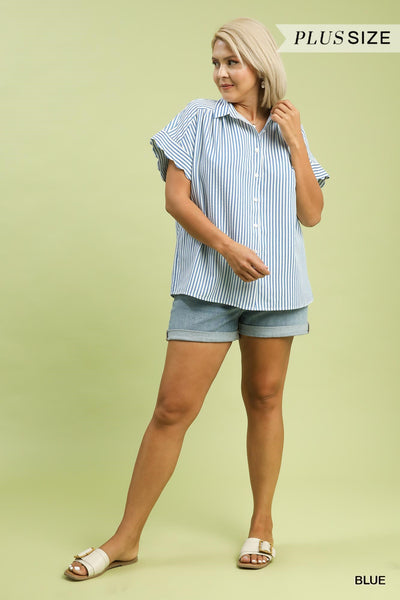 Woman wearing a blue and white striped shirt and denim shorts on a light green background