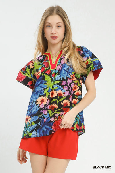 model wearing black multicolor floral blouse with red shorts