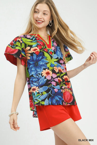 model wearing black multicolor floral blouse with red shorts