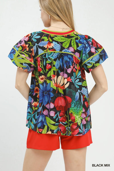 model wearing black multicolor floral blouse with red shorts