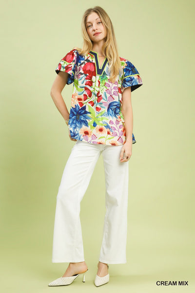 model wearing cream multicolor floral blouse & white pants