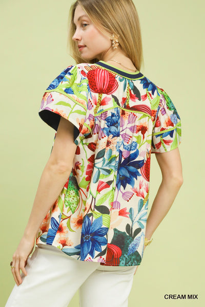 model wearing cream multicolor floral blouse & white pants