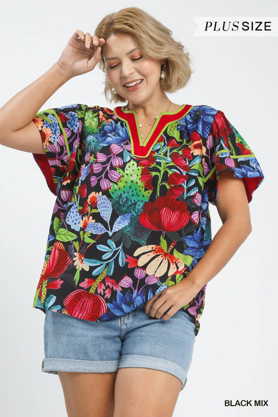 plus model wearing black multicolor floral blouse with cuffed denim shorts