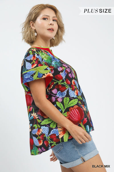 plus model wearing black multicolor floral blouse with cuffed denim shorts
