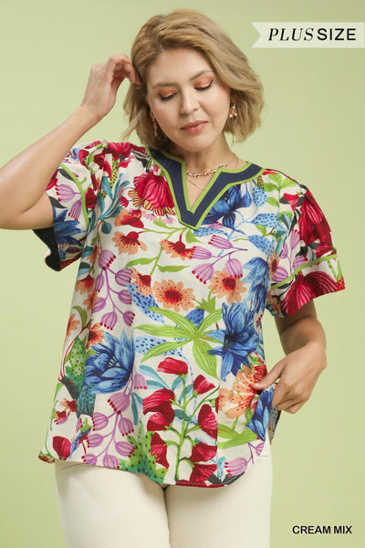 plus model wearing cream multicolor floral blouse with white pants
