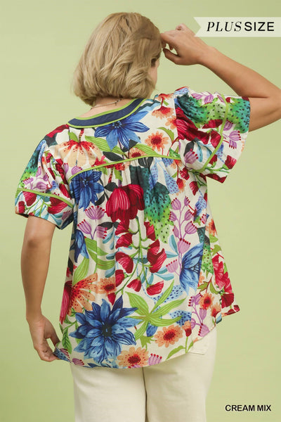 plus model wearing cream multicolor floral blouse with white pants