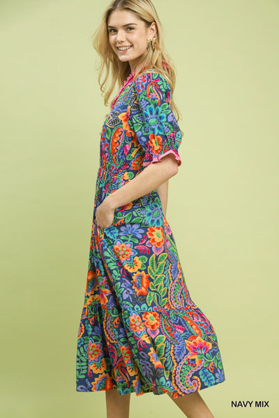model wearing a navy floral dress with a tan background
