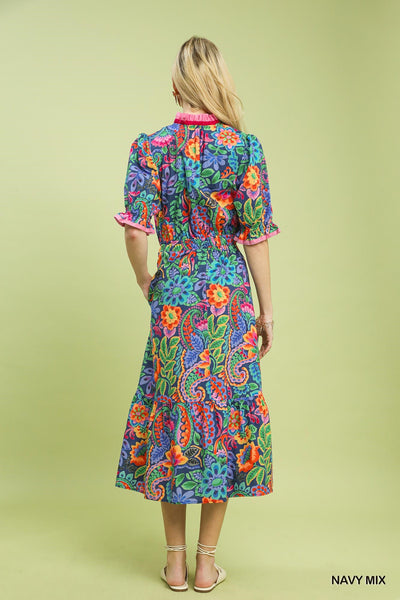 model wearing a navy floral dress with a tan background