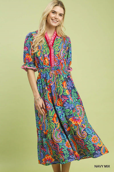 model wearing a navy floral dress with a tan background
